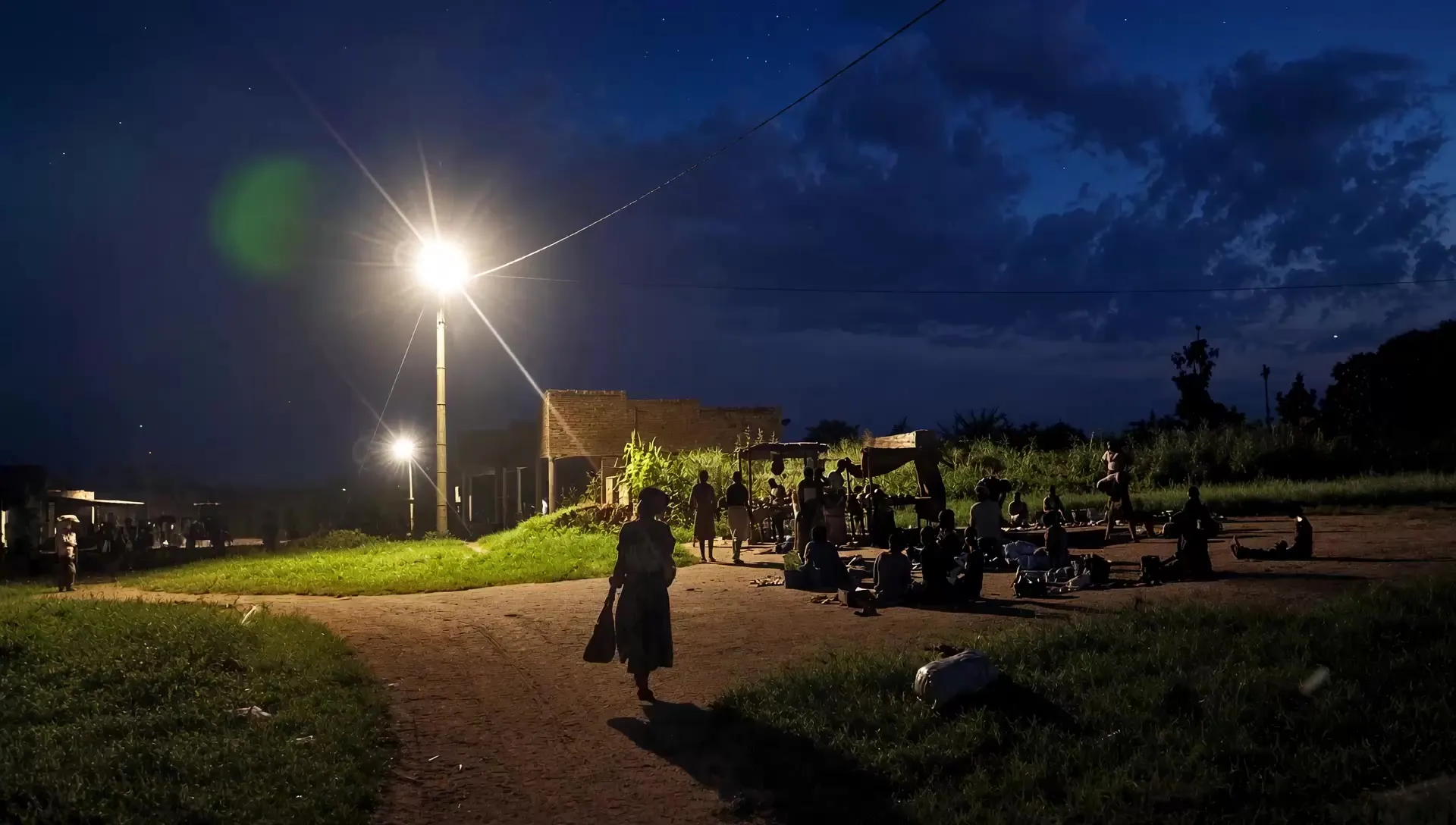 A village street lit after dark by a street light on the Got Ngur mini grid