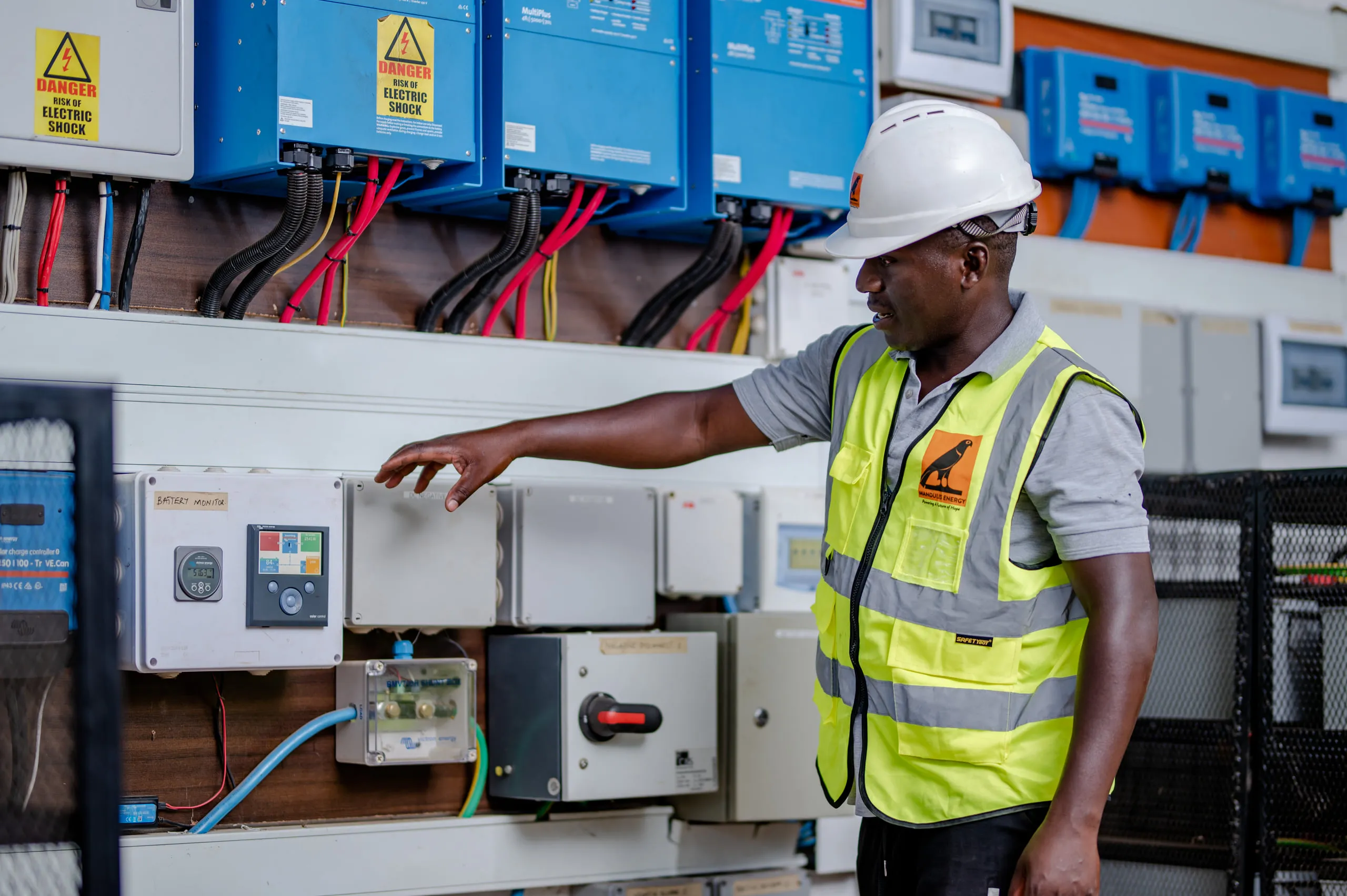 A technician at the inverter and metering panel in the plant control room
