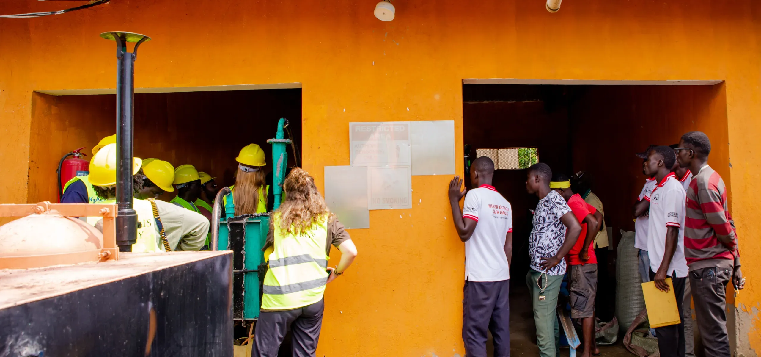 People at the doorways of the Got Ngur control building, with the char collection tank in the foreground